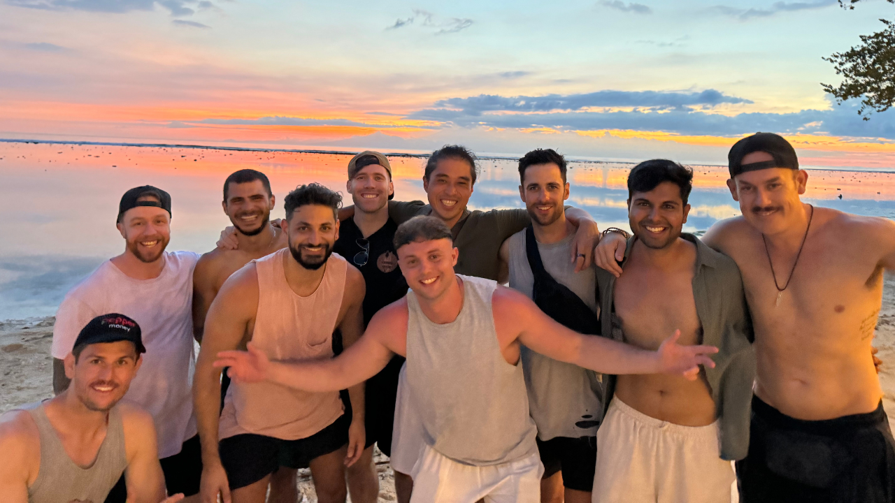 Ben and Alex with clients on the beach at sunset